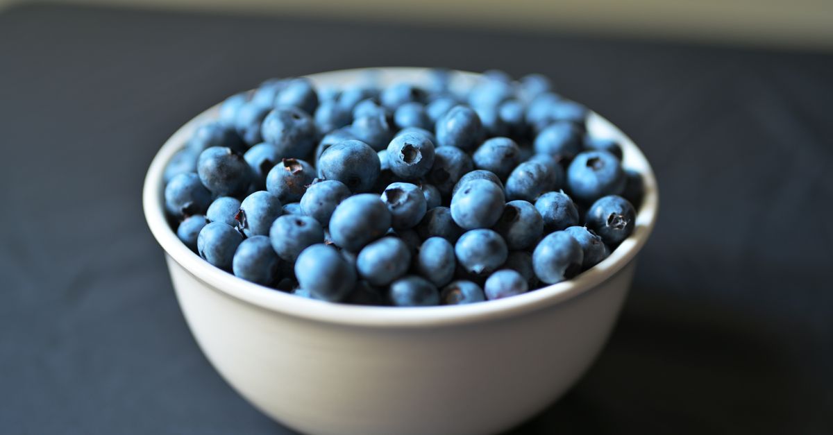 Bowl of fresh blueberries on a dark background, an anti inflammatory food often credited with fat burning