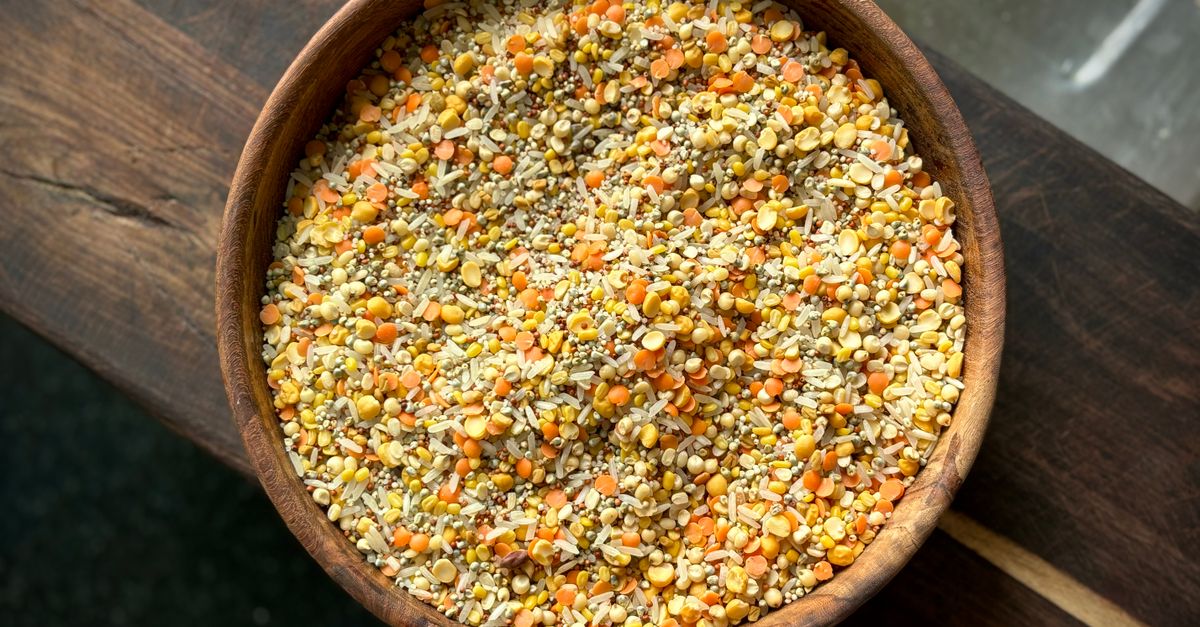 A wooden bowl of mixed millet grains including ragi, jowar and bajra, the flours behind low glycaemic index roti