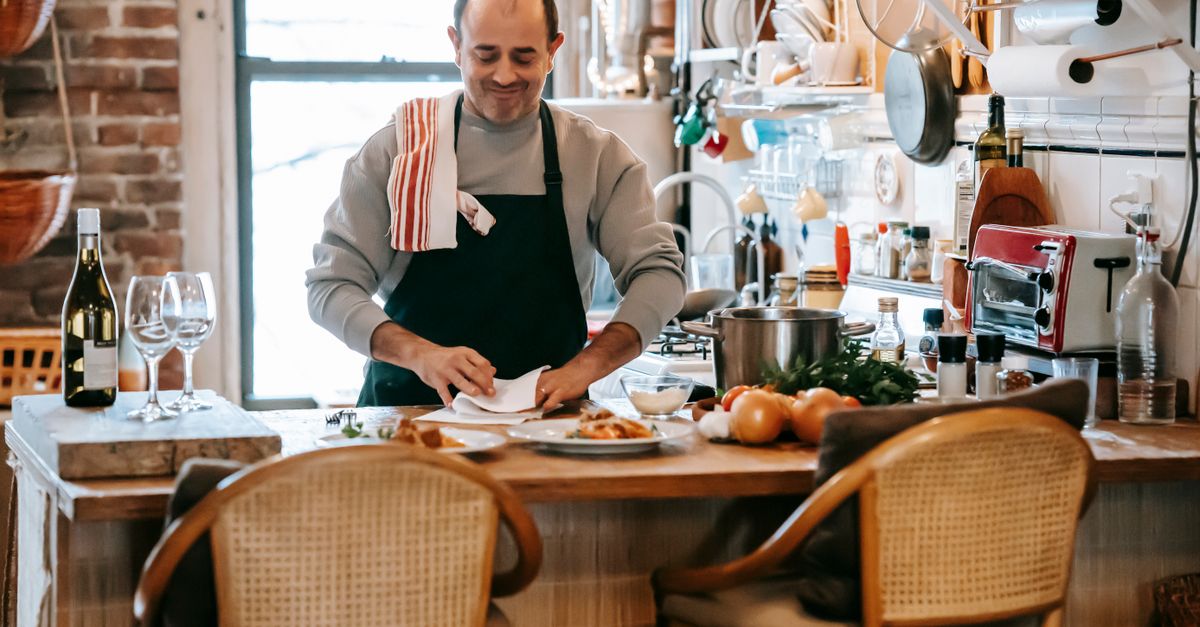 Man plating a home cooked dinner in his kitchen, assembling calories deficit meals from scratch