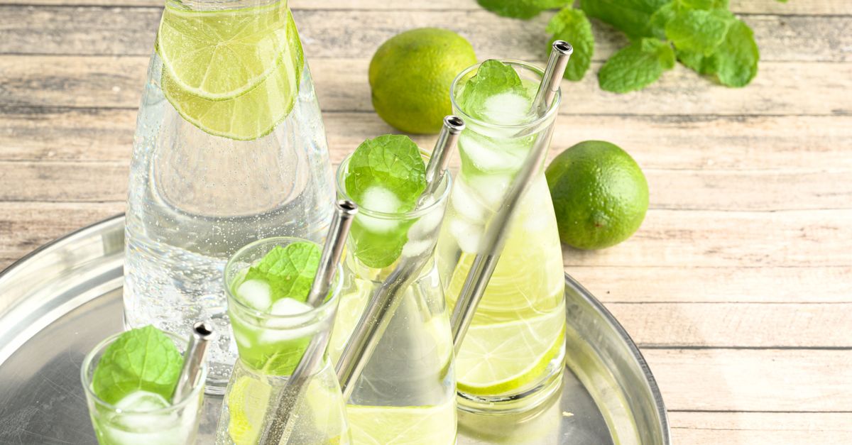 Chilled glasses of lime and mint water on a tray, an unsweetened summer drink like barley water