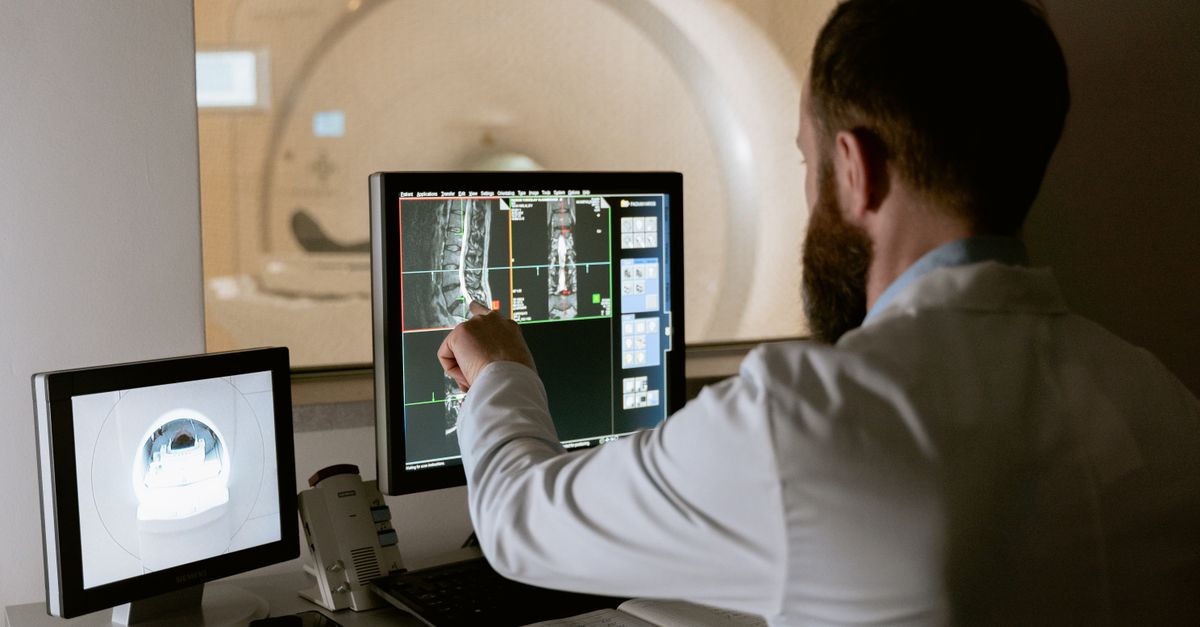 A doctor reviewing scan images on a monitor, the imaging that tells belly fat types apart