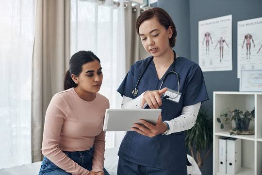 Clinician showing a patient results on a tablet, the assessment route for anyone asking how to know my body fat percentage