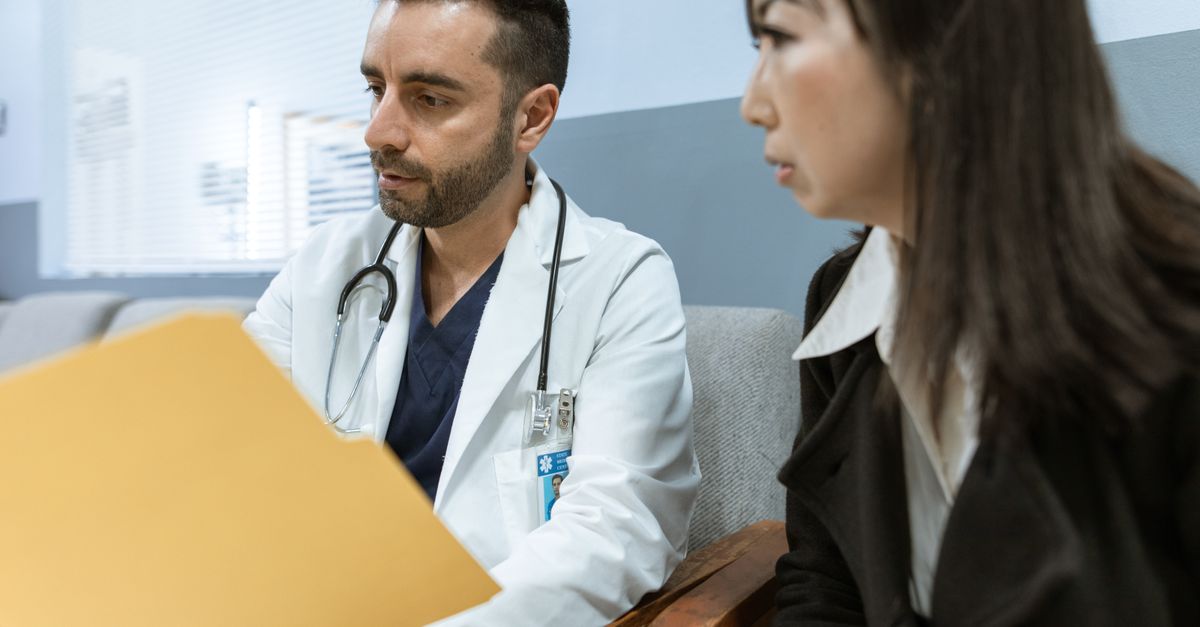 Doctor going through printed test results with a patient at a desk