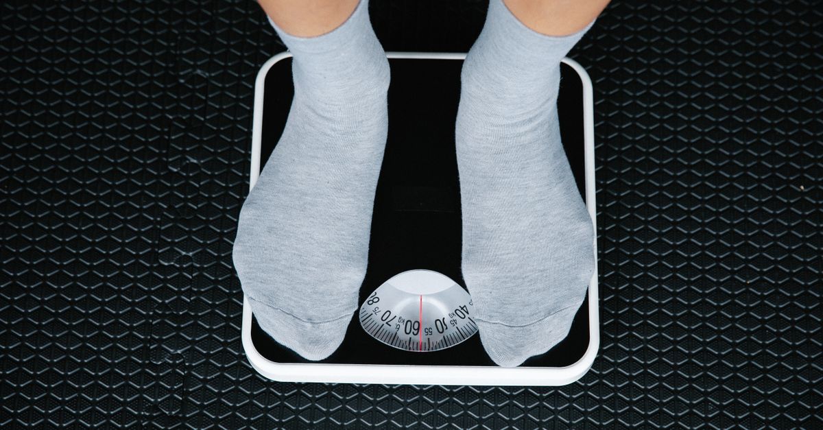 Feet in socks standing on a bathroom scale, showing the early scale movement people notice on the Dukan Diet