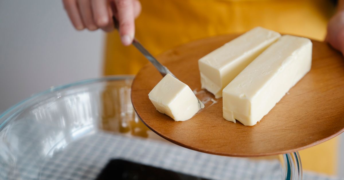 Butter being sliced on a wooden board