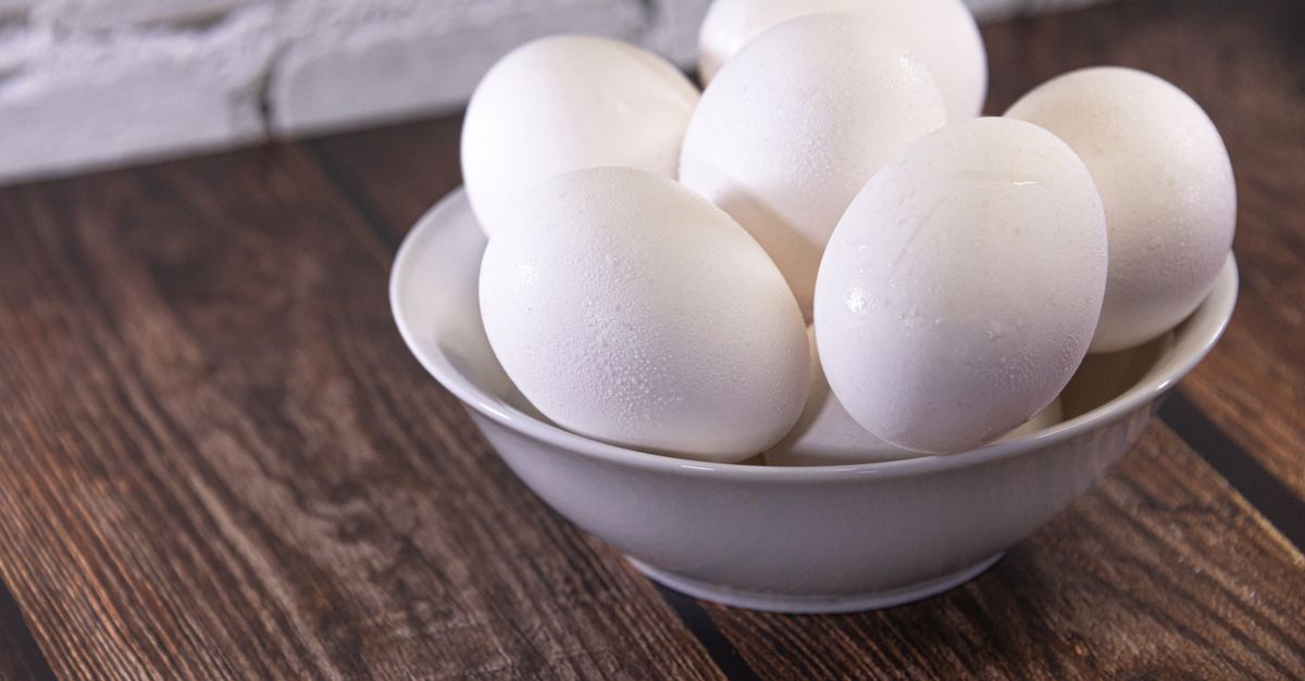 Fresh white eggs piled in a ceramic bowl on a wooden table, the whole egg fast menu