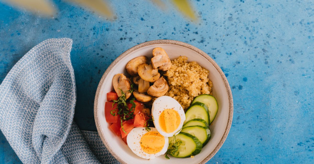 Breakfast bowl of quinoa, boiled eggs and cucumber, a balanced plate that helps quiet food noise