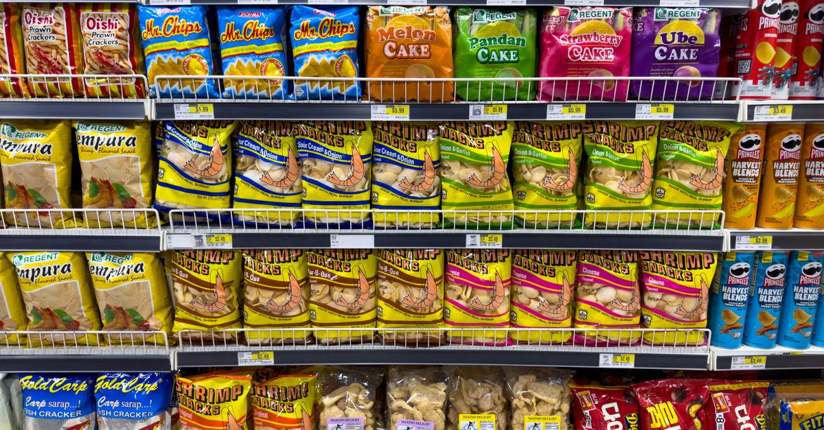 Rows of packaged snack products on supermarket shelves, the ultra-processed end of food quality