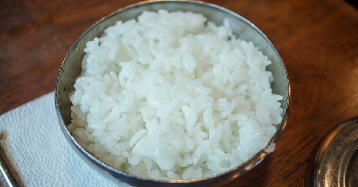 Bowl of steamed white rice on a table, carbohydrate whose stored glycogen holds water and shifts scale weight