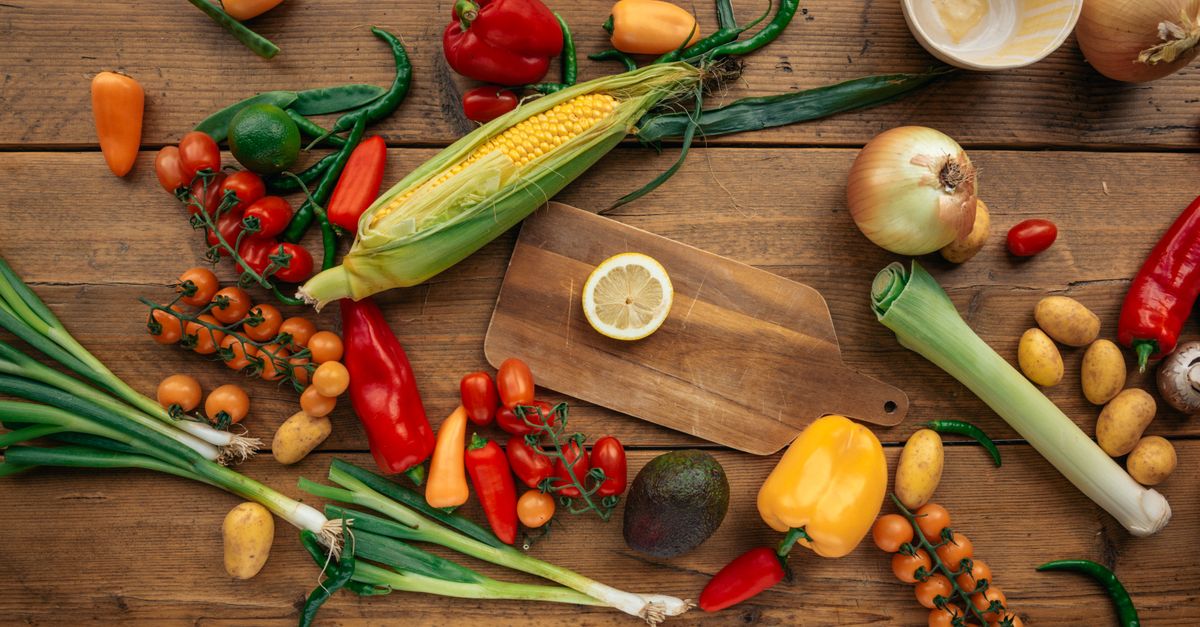 Fresh vegetables and fruit spread across a wooden table, the foods the 7 day GM diet is built around
