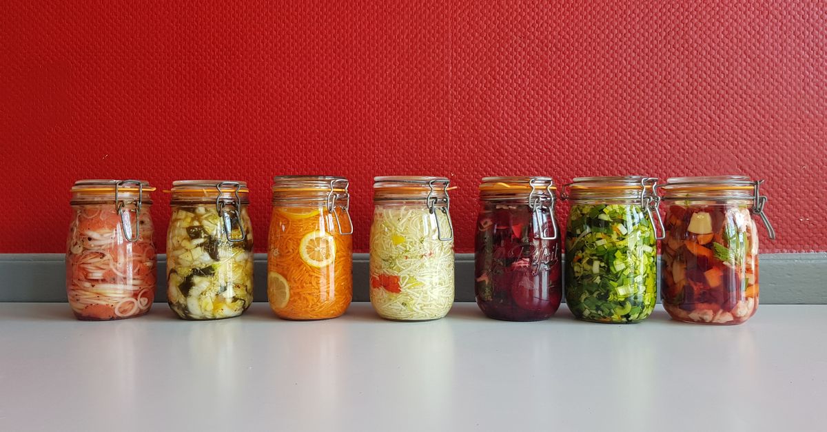 Row of glass jars of home fermented vegetables on a shelf, the fermented foods tested for gut microbiome diversity