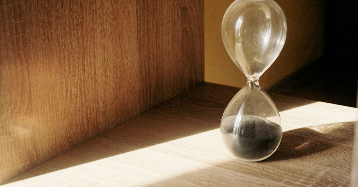 Glass hourglass on a sunlit wooden shelf, marking the months between a crash diet and hair loss