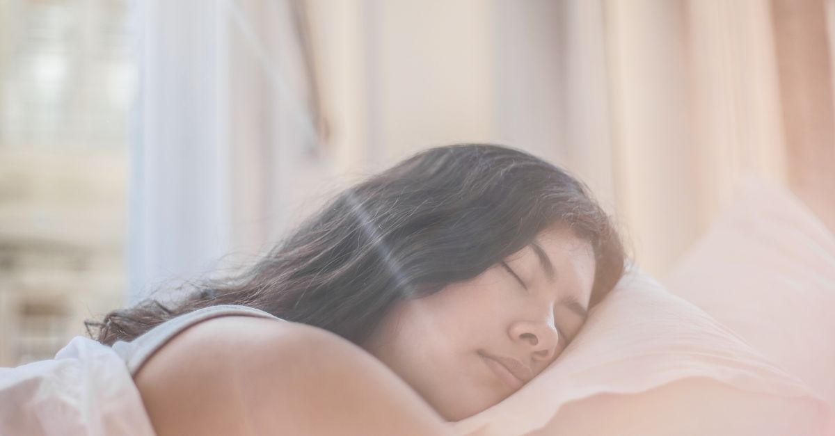 Woman asleep on a pillow in morning light, since sleep changes facial puffiness faster than face fat