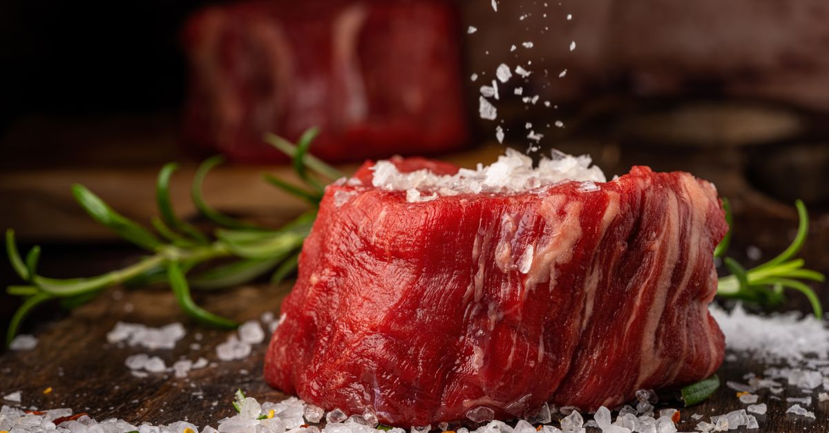 Raw beef steak seasoned with salt and rosemary, red meat being the richest dietary source of L-carnitine