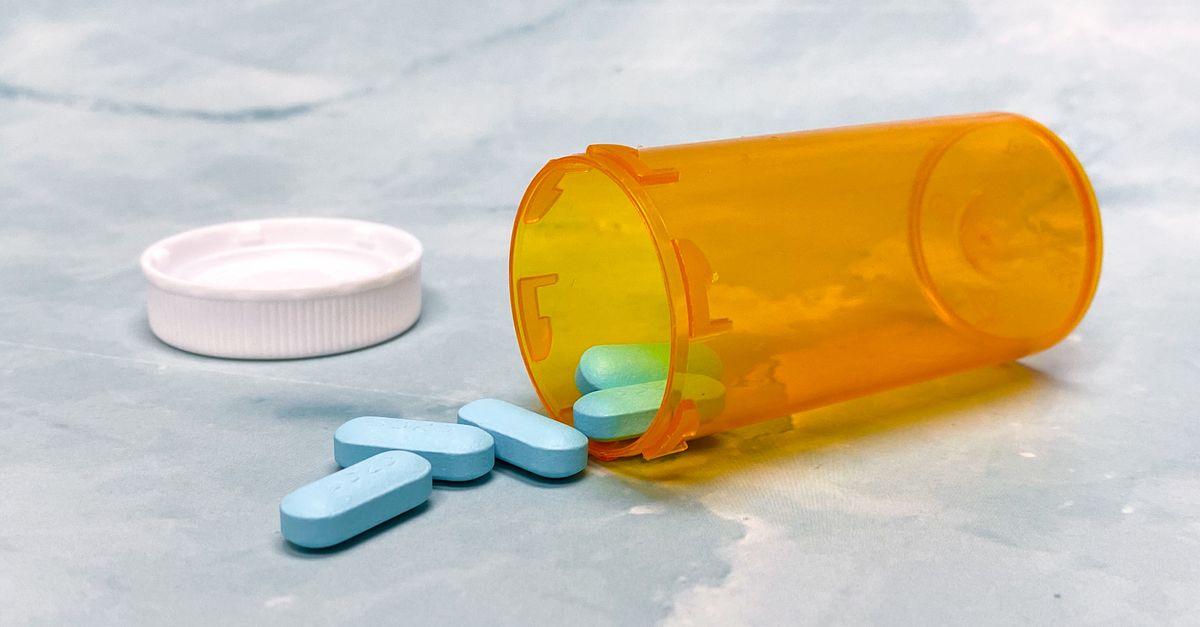 Prescription bottle tipped over with tablets spilling onto a counter, medication timing to raise before intermittent fasting