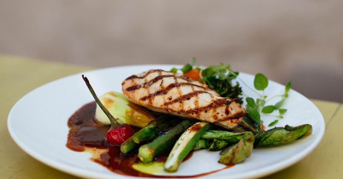 A plate of grilled chicken and green vegetables, the kind of smaller meal that satisfies while taking Ozempic