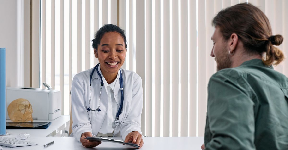 A doctor in a white coat talking with a patient at a desk about a prescription such as Ozempic