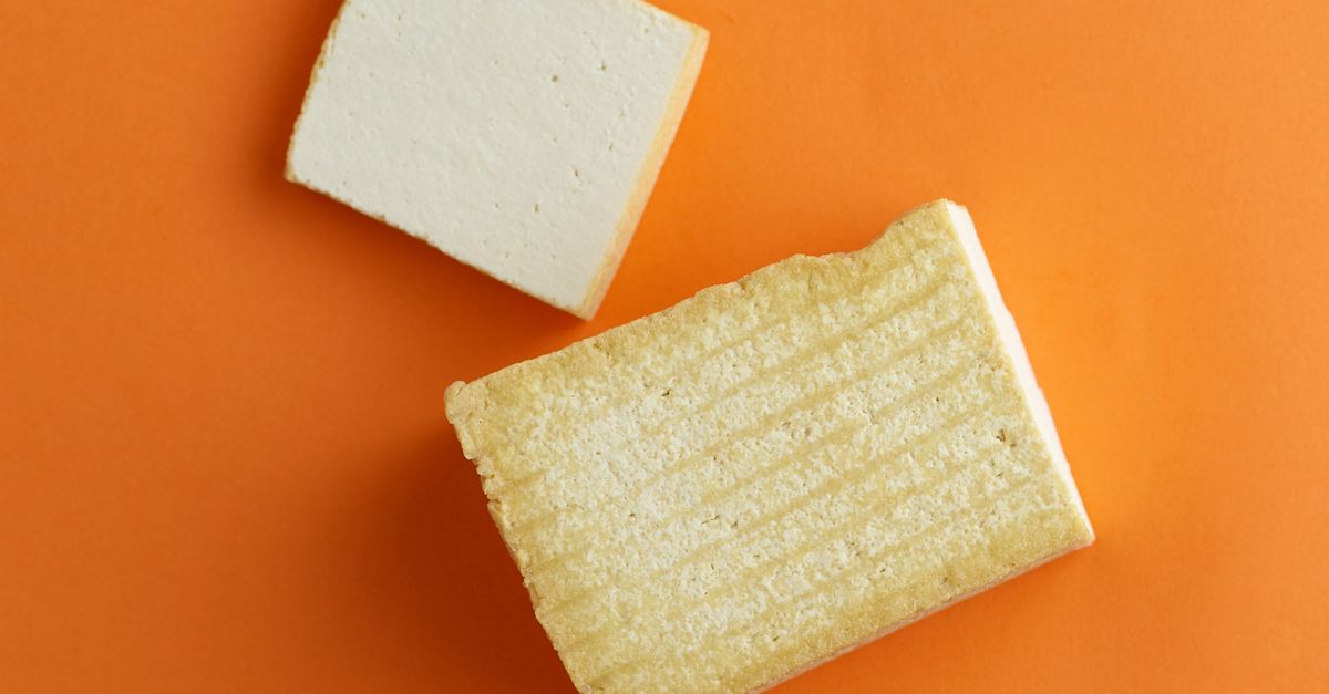 Two plain blocks of tofu on an orange background