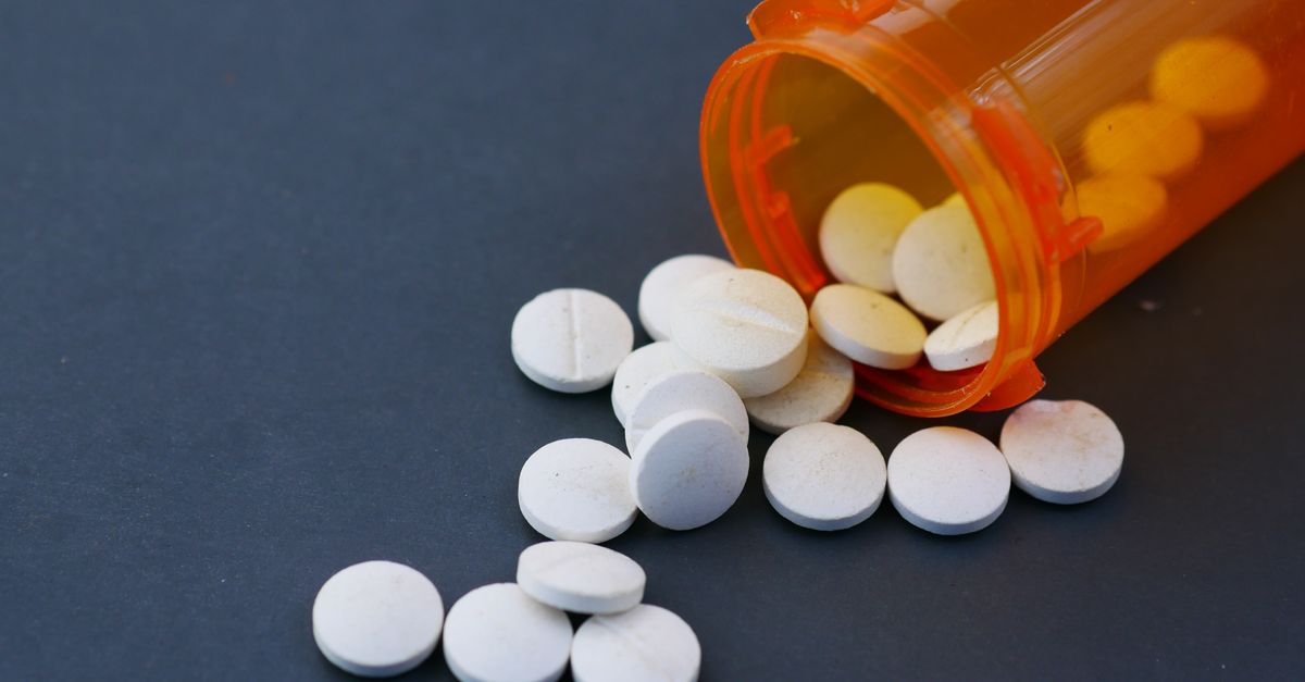 White tablets spilling from an orange prescription bottle, the kind of medicine grapefruit can interact with