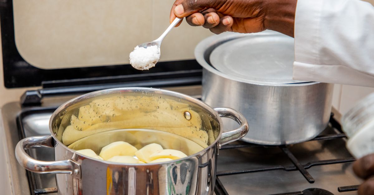 A spoonful of salt added to a pot on the stove, the iodised salt Indian cooking relies on