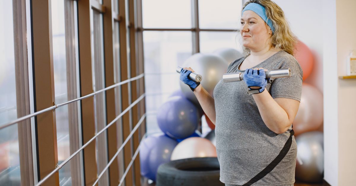 Woman lifting light dumbbells in a gym