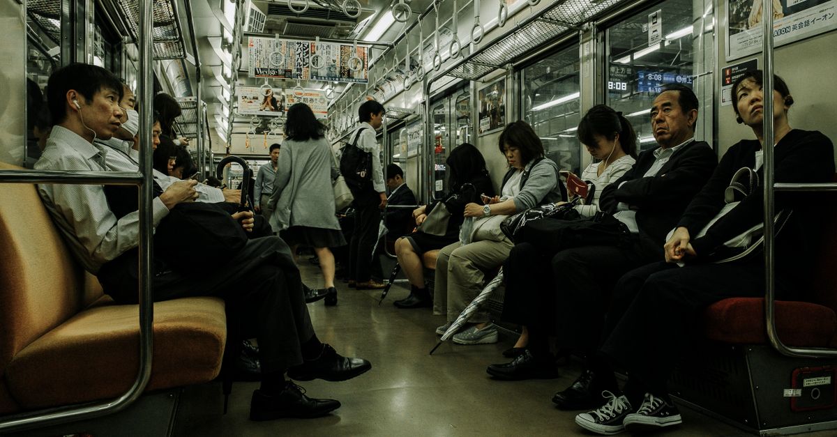 Passengers seated and standing in a crowded commuter train, the repeated daily stress that affects metabolism