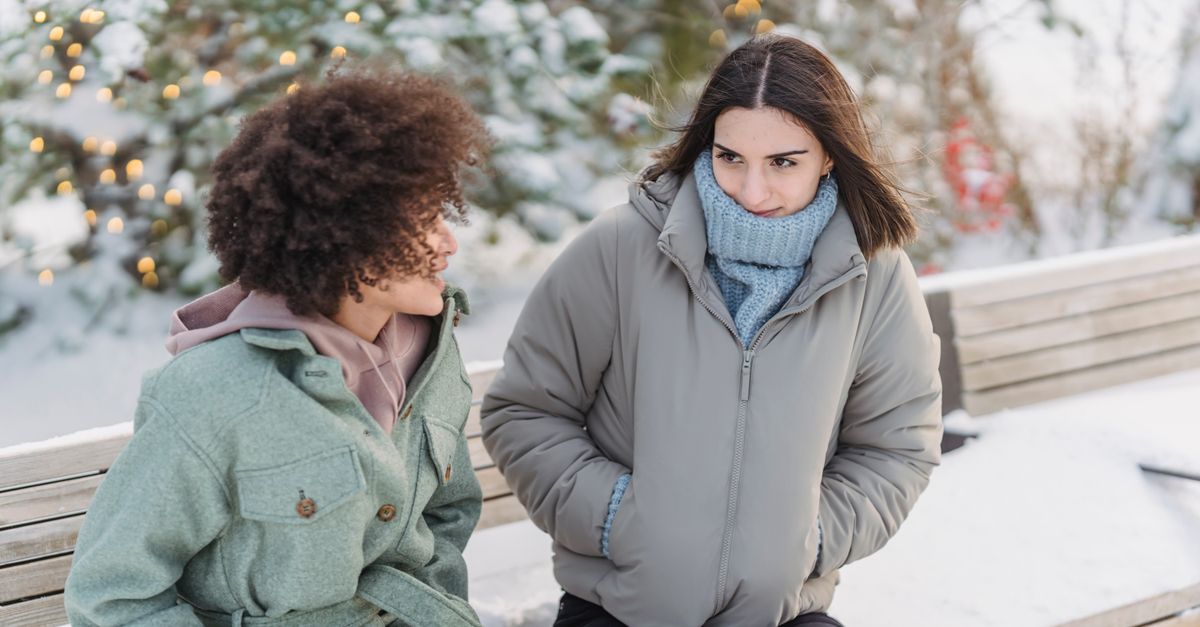 Two women talking on an outdoor bench, social contact as a buffer against stress and its effect on metabolism
