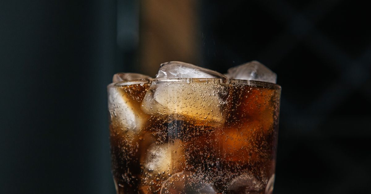 Glass of dark fizzy drink filled with ice cubes, the largest sugar source for many people