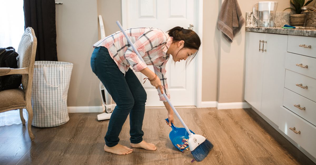 Woman sweeping a floor with a broom and dustpan, the everyday movement a slow metabolism gets blamed for