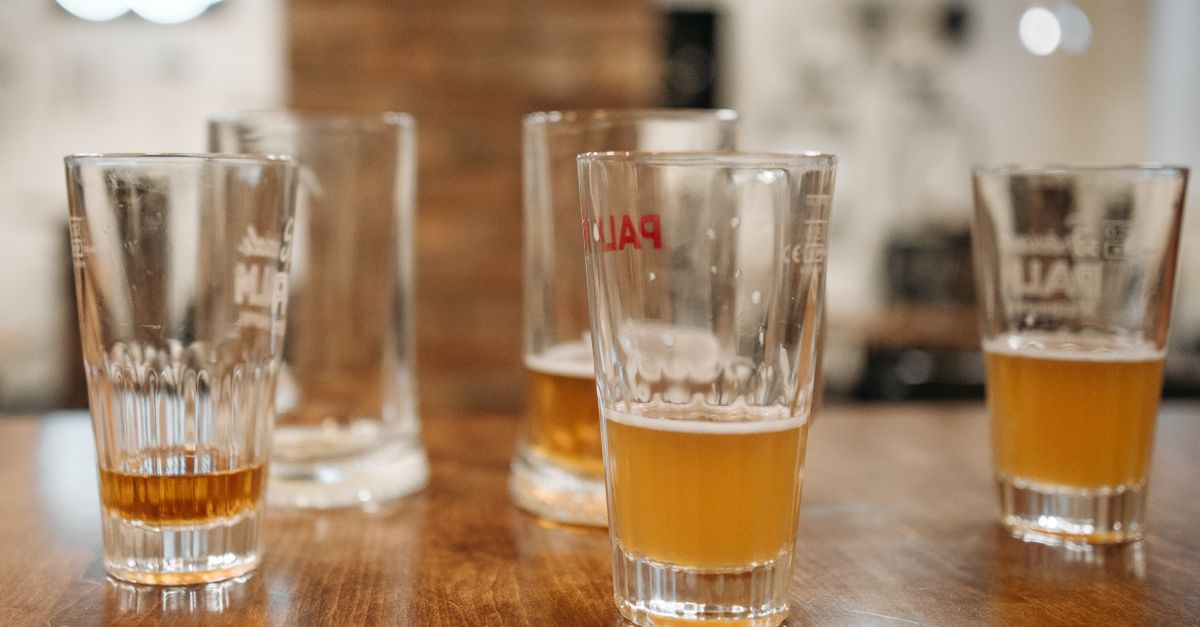 Half finished beer glasses on a wooden table, alcohol linked to abdominal and visceral fat