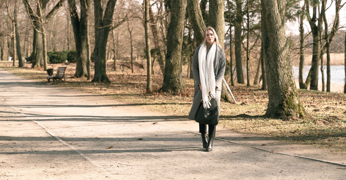 Woman walking along a paved park path on a sunny day