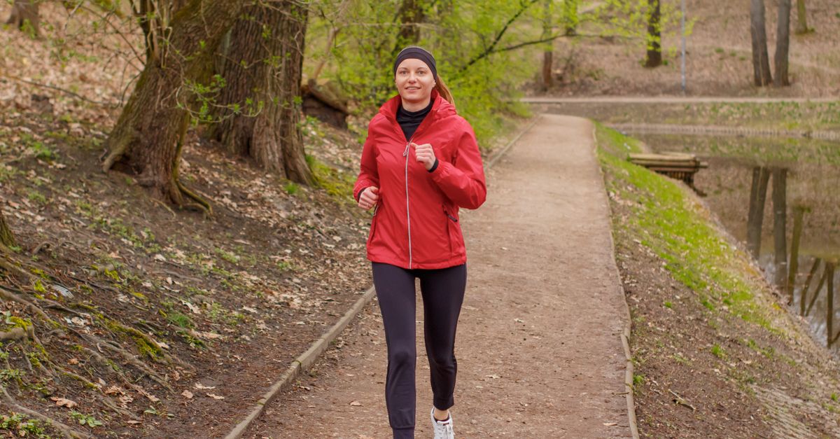 A woman jogging on a park path, because upper body exercises cannot empty fat from one area