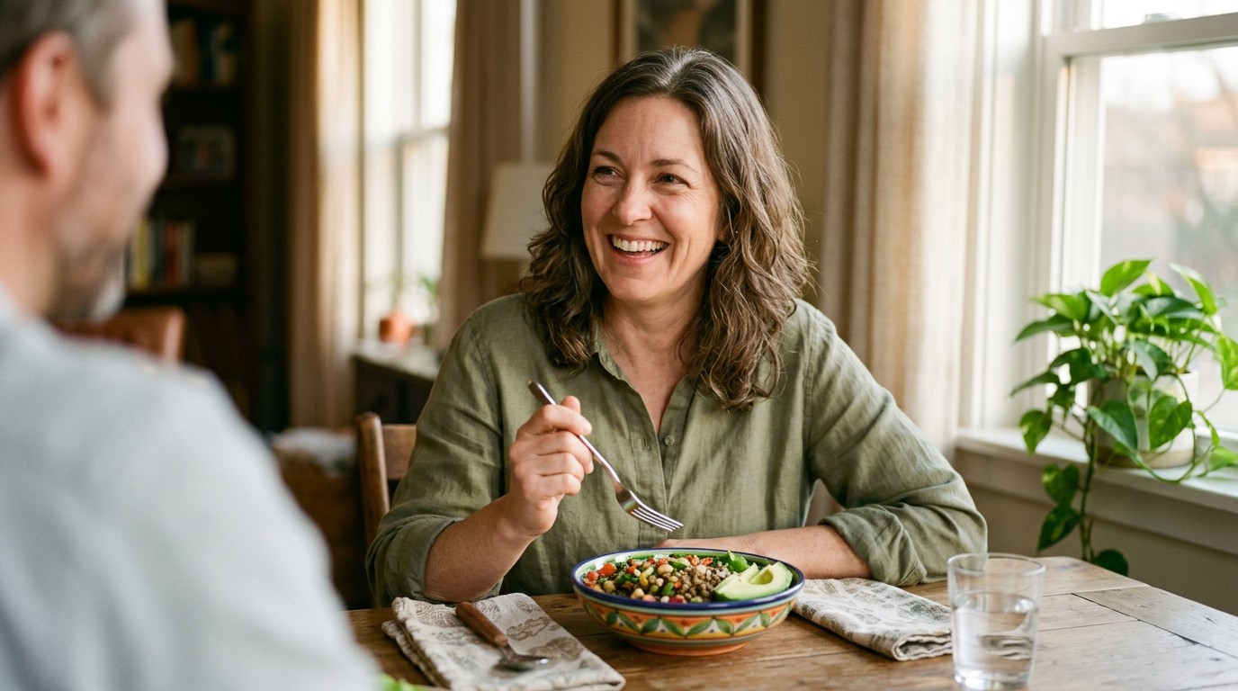 Woman smiling over a lentil bowl at a dining table, keeping up a high protein diet for weight loss